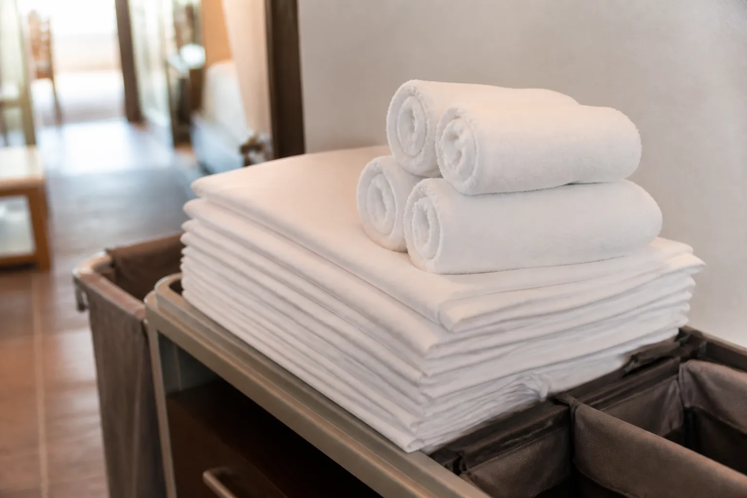 Stack of folded sheets and towels ready for the housekeeping cart
